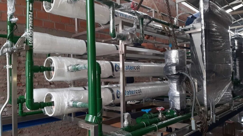 Bastidor de ósmosis inversa de doble paso en fabricación: portamembranas rotulados Watercol y tubería de permeado en verde.